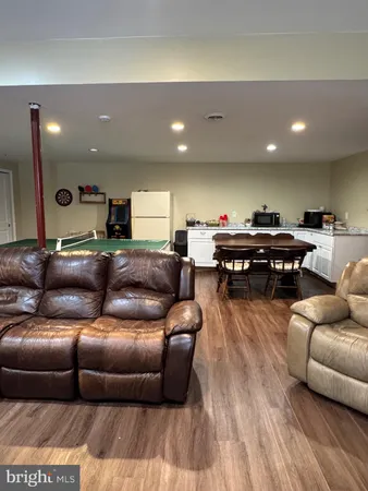 a living room with furniture a wooden floor and a sink