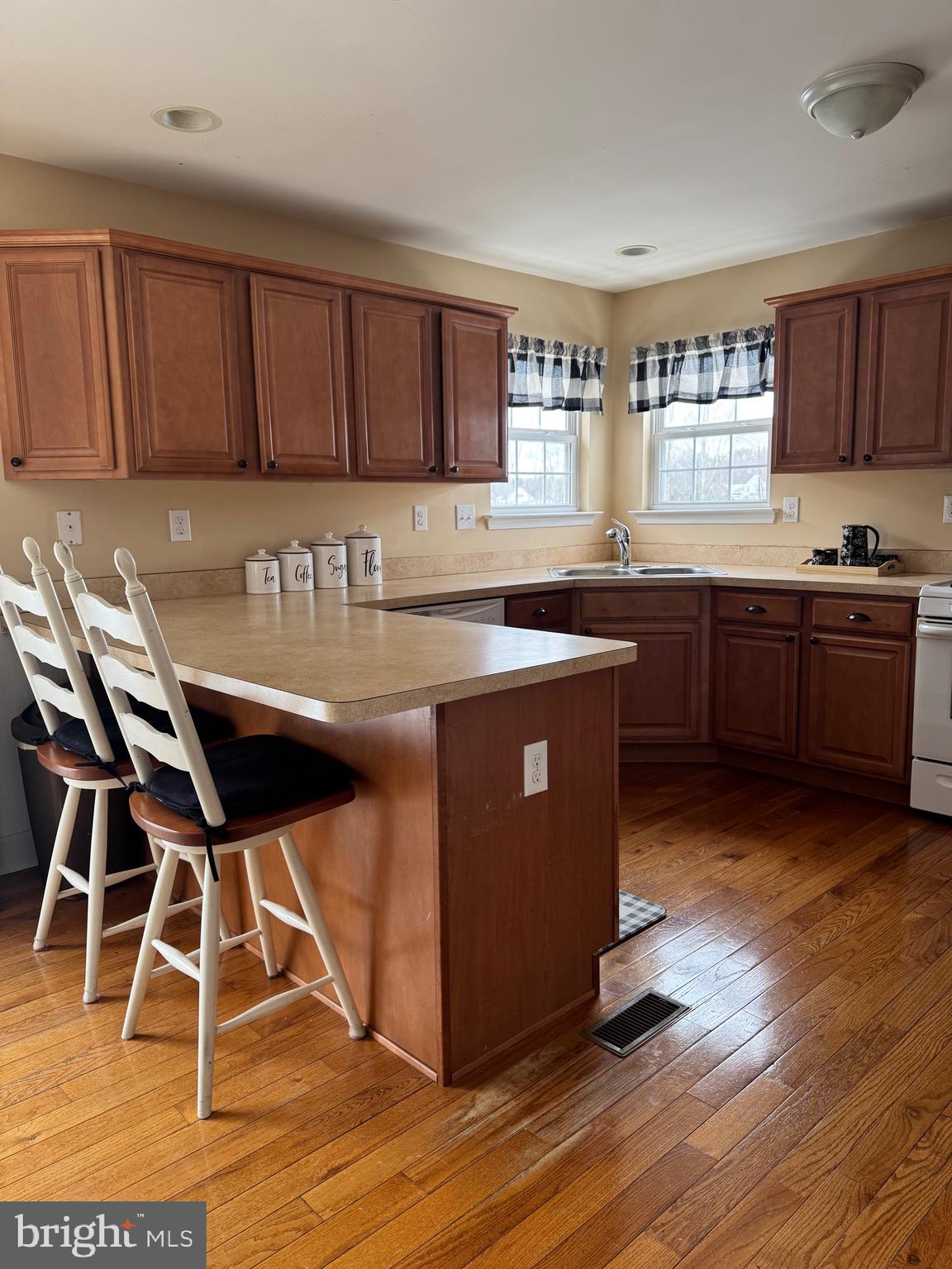 5432 Lake Road Newfield, NJ 08344 - Photo 3 of 24 a kitchen with stainless steel appliances granite countertop wooden floors and wooden cabinets