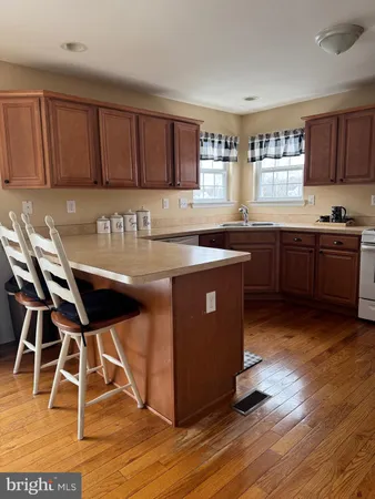 a kitchen with stainless steel appliances granite countertop wooden floors and wooden cabinets