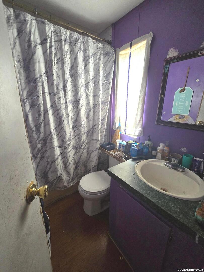 408 Hickory Street Jourdanton, TX 78026 - Photo 4 of 9 a bathroom with a toilet sink and mirror