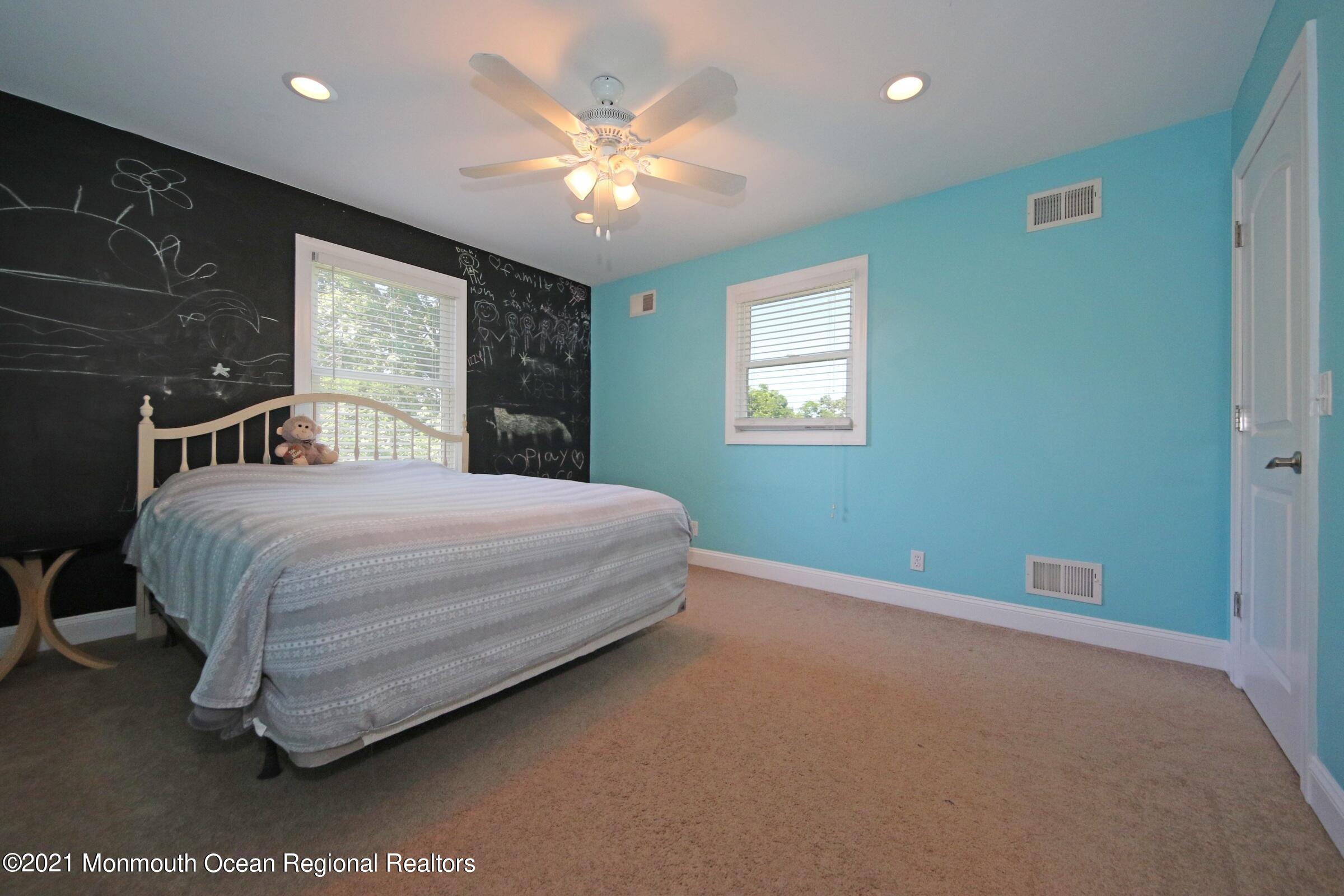 27 Demmert Avenue Rumson, NJ 07760 - Photo 11 of 38 a bedroom with a bed and a chandelier