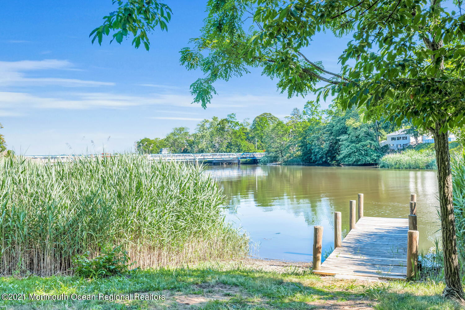27 Demmert Avenue Rumson, NJ 07760 - Photo 33 of 38 a wooden bench sitting next to a lake