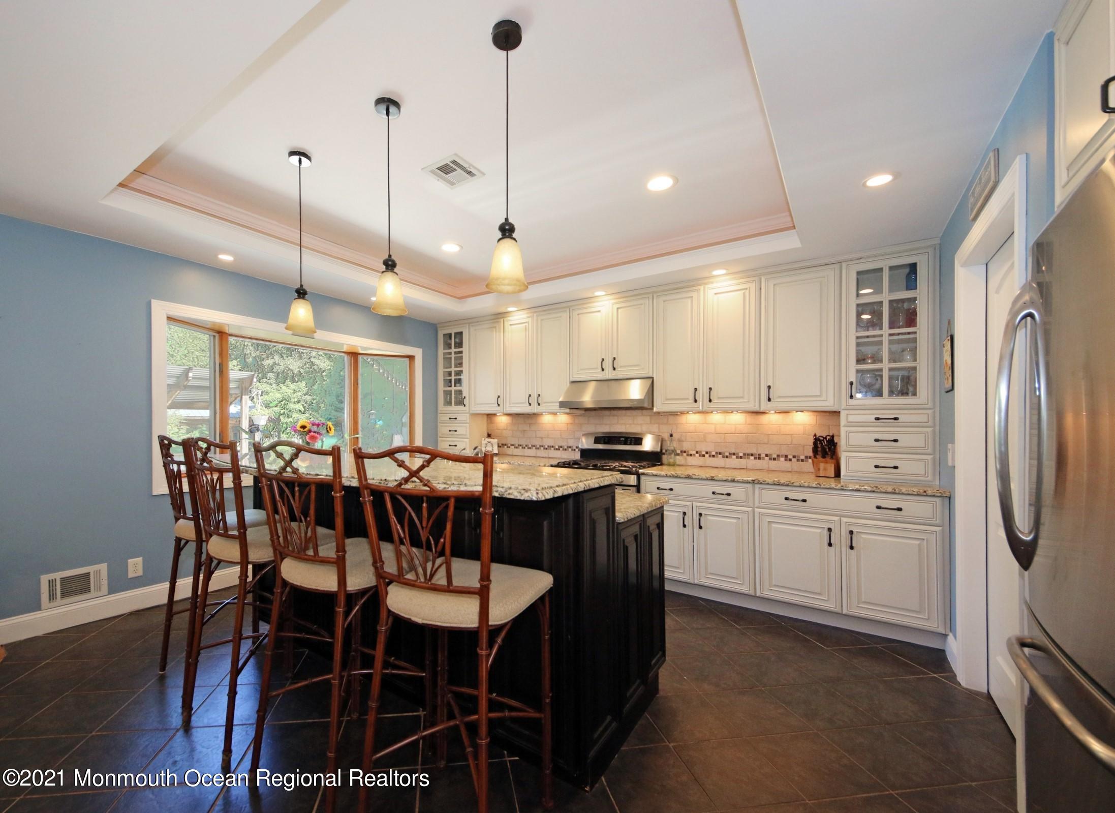 27 Demmert Avenue Rumson, NJ 07760 - Photo 5 of 38 a kitchen with stainless steel appliances granite countertop a kitchen island a table and chairs in it
