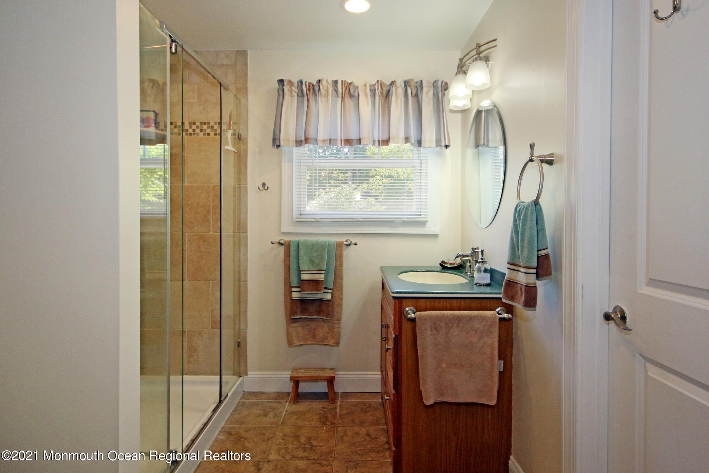 27 Demmert Avenue Rumson, NJ 07760 - Photo 9 of 38 a bathroom with a sink a mirror a vanity and shower