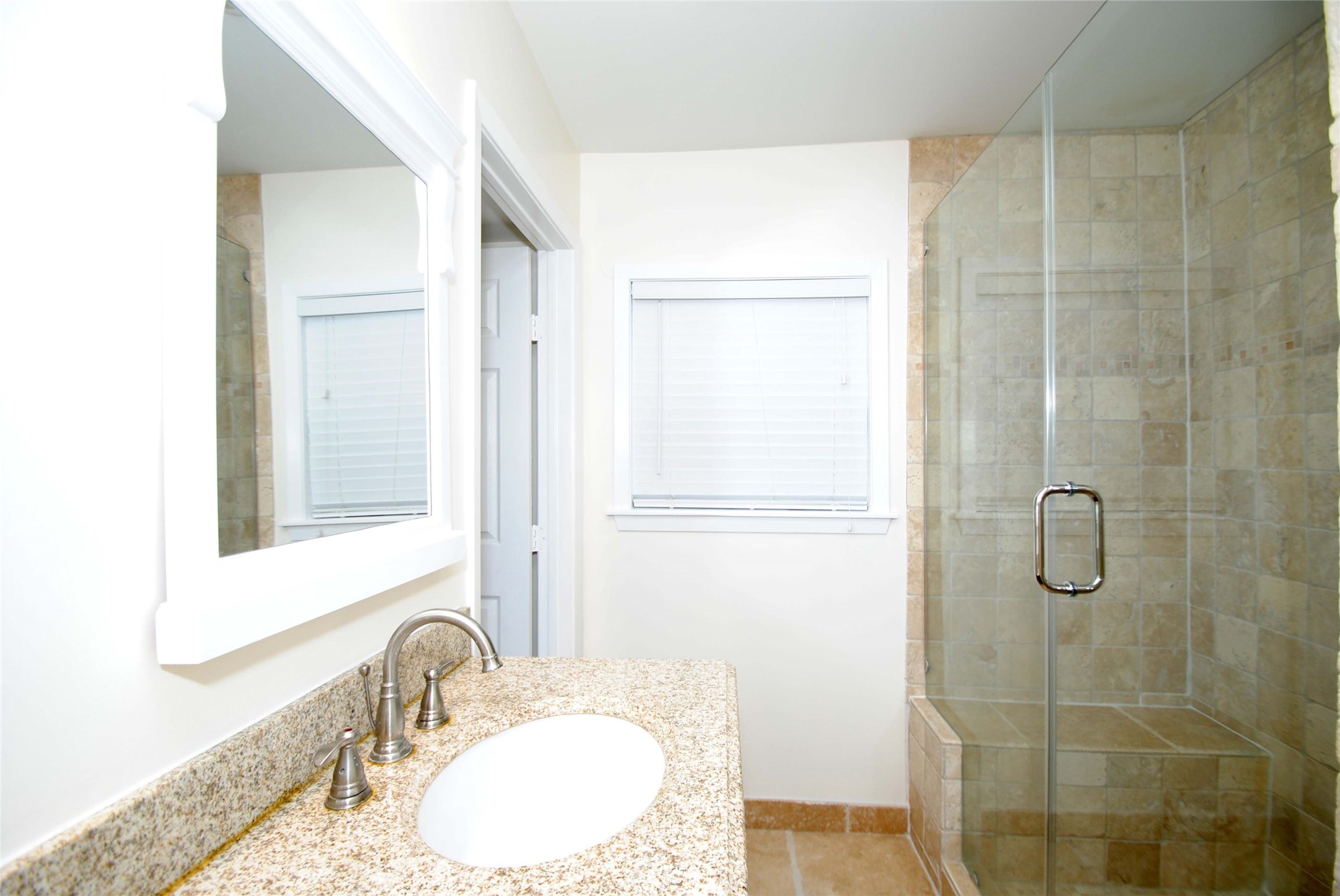 7953 Ridgeview Drive Houston, TX 77055 - Photo 19 of 29 a bathroom with a granite countertop sink a mirror and a shower