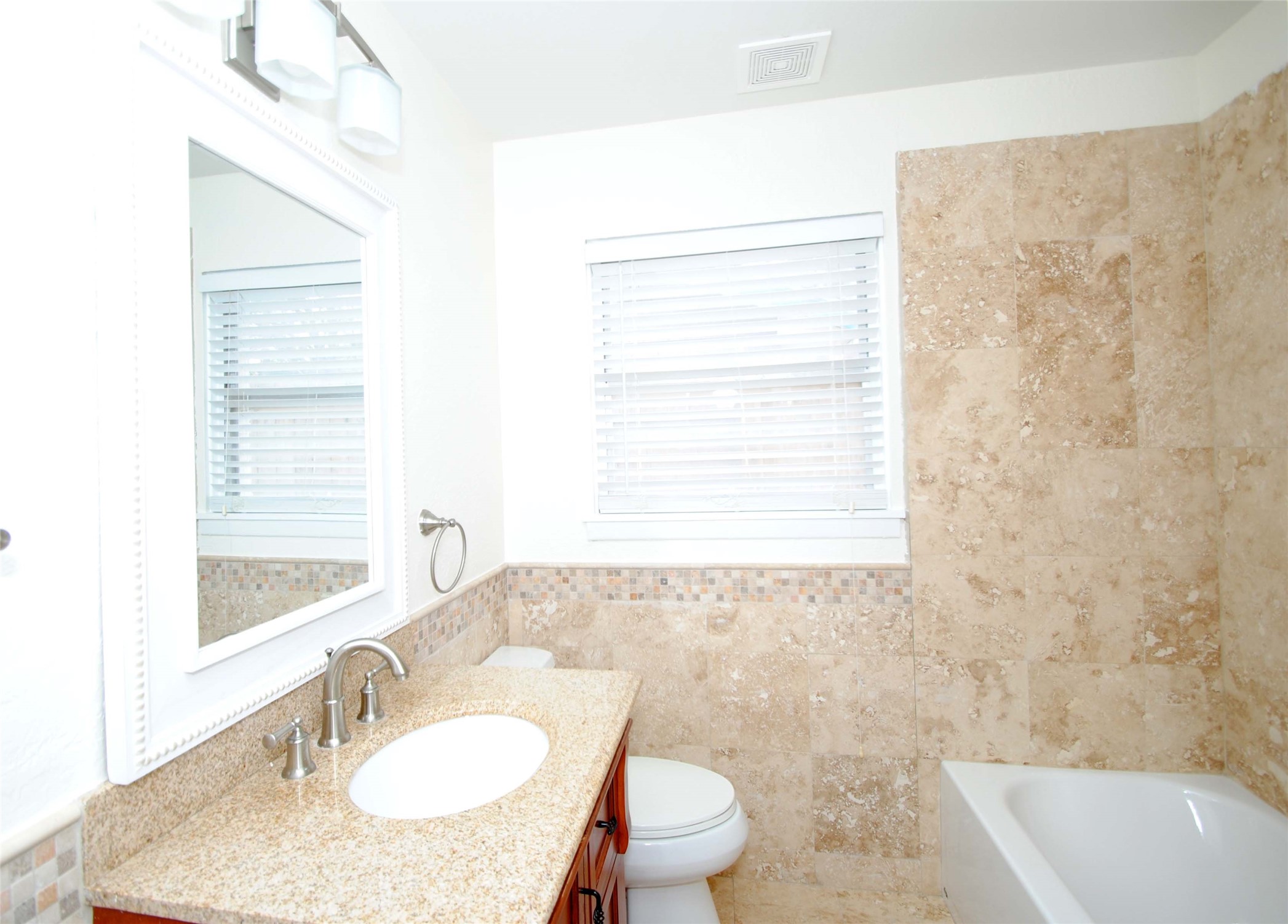 7953 Ridgeview Drive Houston, TX 77055 - Photo 21 of 29 a bathroom with a granite countertop sink toilet a mirror and a tub
