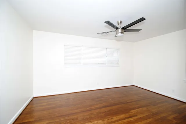a view of a room with wooden floor and a ceiling fan