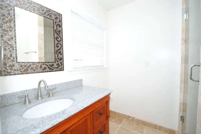 a bathroom with a granite countertop sink and a mirror