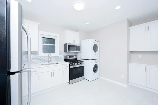 a kitchen with stainless steel appliances a refrigerator sink and stove