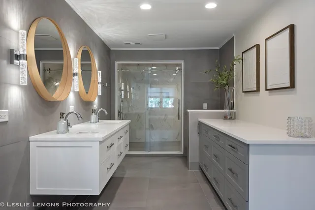 a spacious bathroom with a double vanity sink toilet mirror and shower