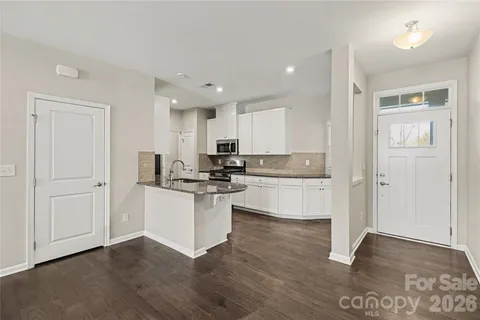 a kitchen with granite countertop white cabinets and white appliances
