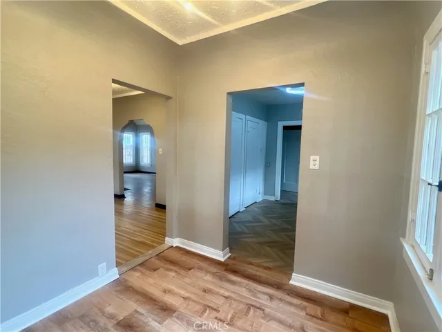 a view of a hallway with wooden floor and a livingroom