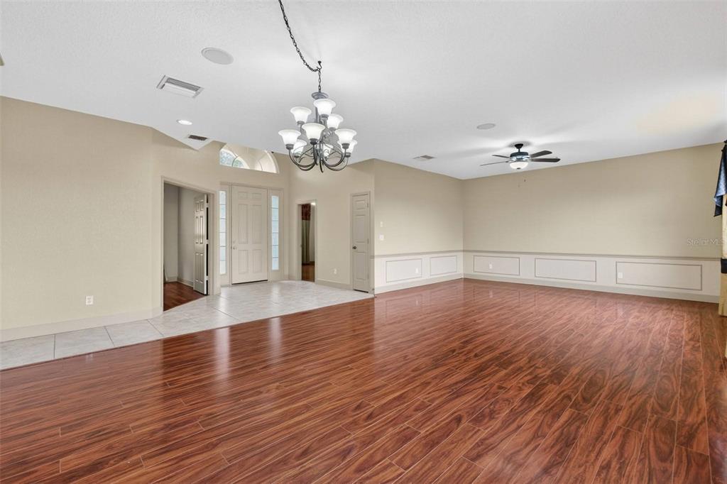 3463 Forest Ridge Lane Kissimmee, FL 34741 - Photo 14 of 58 a view of a room with wooden floors and chandelier