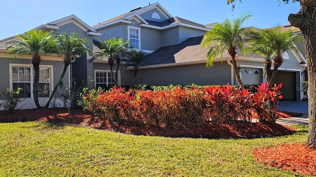 3463 Forest Ridge Lane Kissimmee, FL 34741 - Photo 2 of 58 a front view of a house with a big yard and potted plants