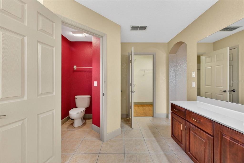 3463 Forest Ridge Lane Kissimmee, FL 34741 - Photo 39 of 58 a spacious bathroom with a sink a toilet and a large mirror