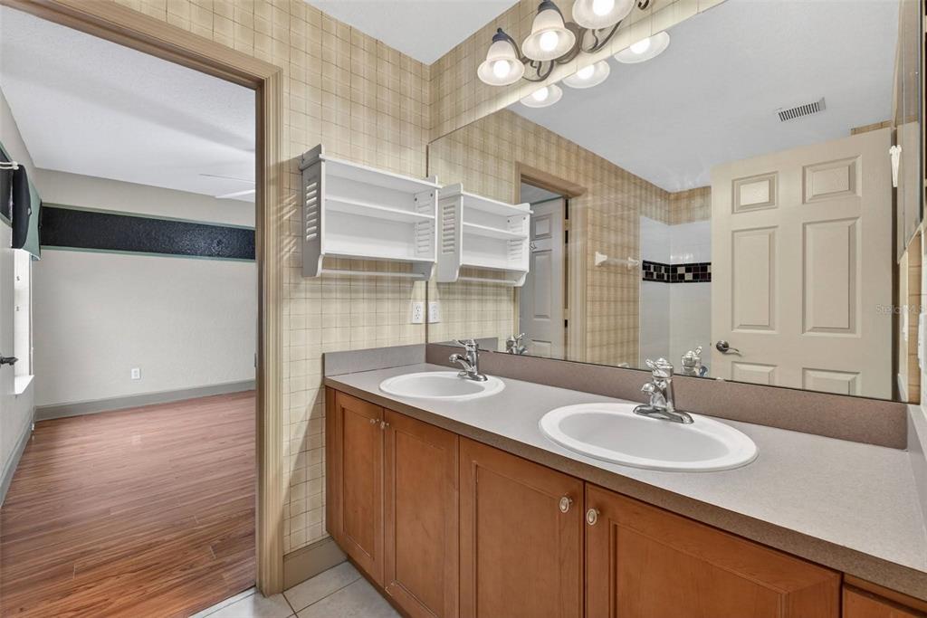 3463 Forest Ridge Lane Kissimmee, FL 34741 - Photo 43 of 58 a bathroom with a sink double vanity and a mirror