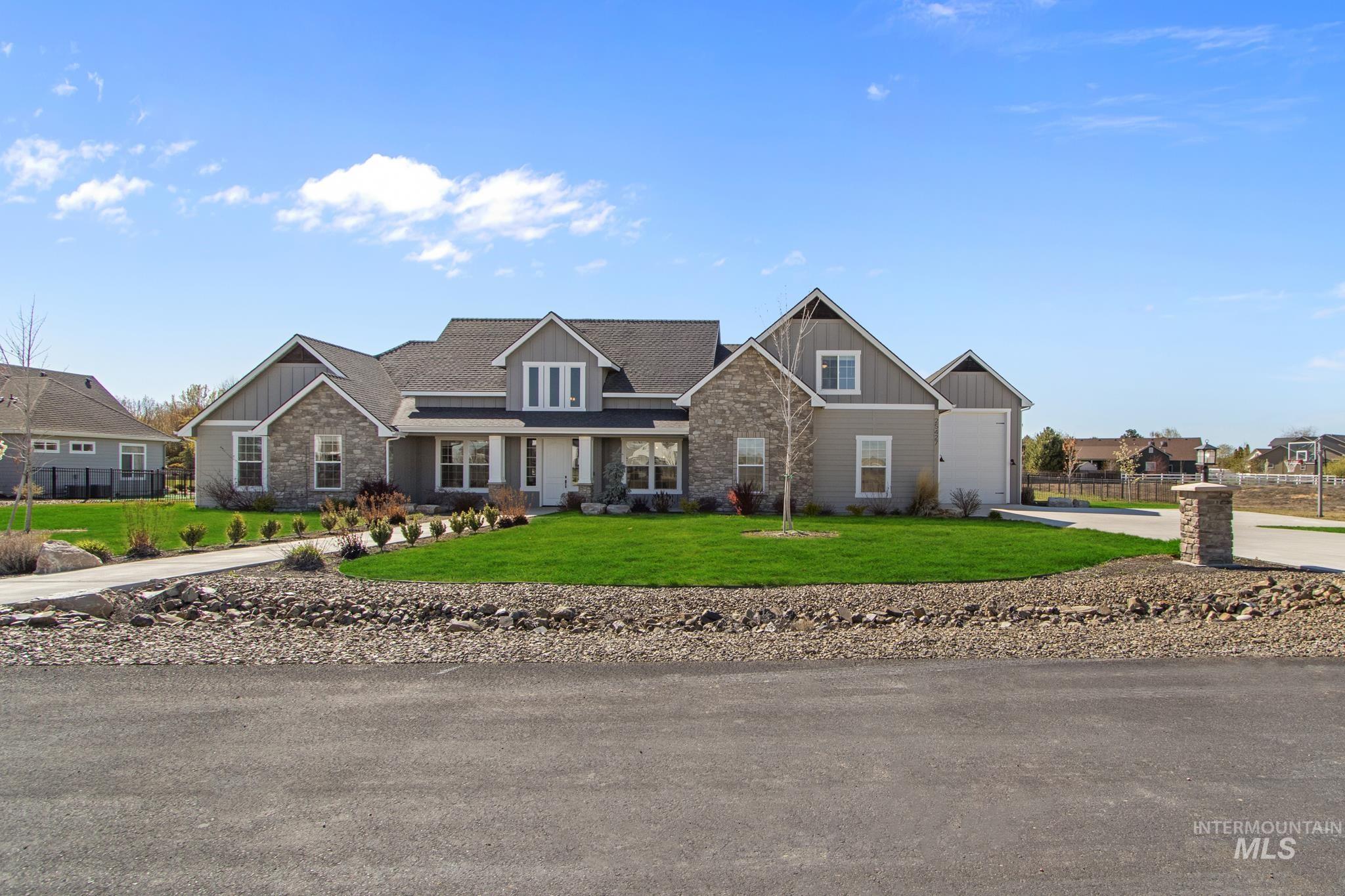 Craftsman-style home featuring board and batten siding, a front lawn, stone siding, and a porch