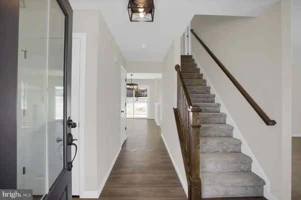 a view of a hallway with wooden floor and entryway
