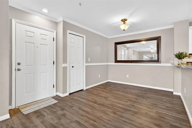 a view of an empty room with window and wooden floor