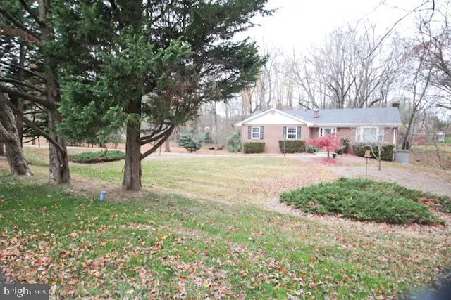 a front view of a house with a yard and trees