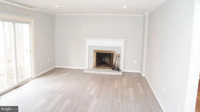 a view of an empty room with a window and a fireplace