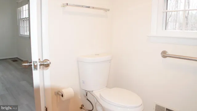 a white toilet sitting next to a window