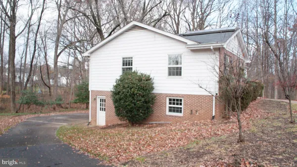 a view of a white house with a yard and large tree