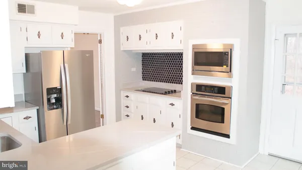 a kitchen with stainless steel appliances a refrigerator and cabinets