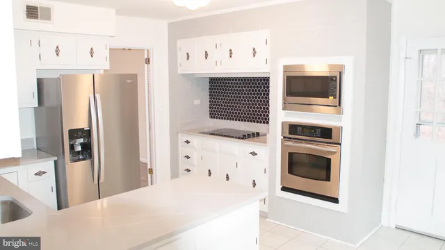 a kitchen with stainless steel appliances a refrigerator and cabinets