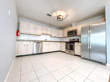 a kitchen with stainless steel appliances granite countertop a refrigerator and a stove top oven