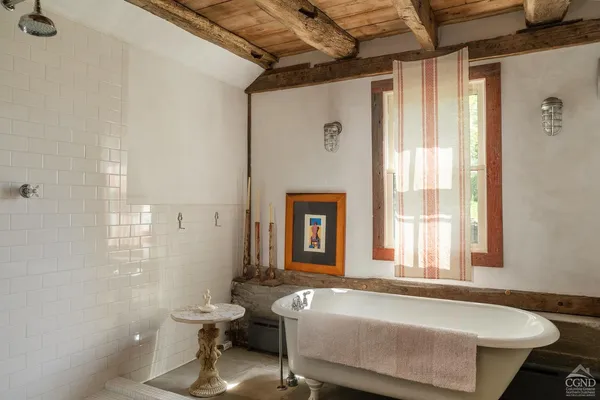 a bathroom with a tub sink and mirror