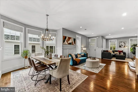 a kitchen with granite countertop a refrigerator a stove a sink and chairs