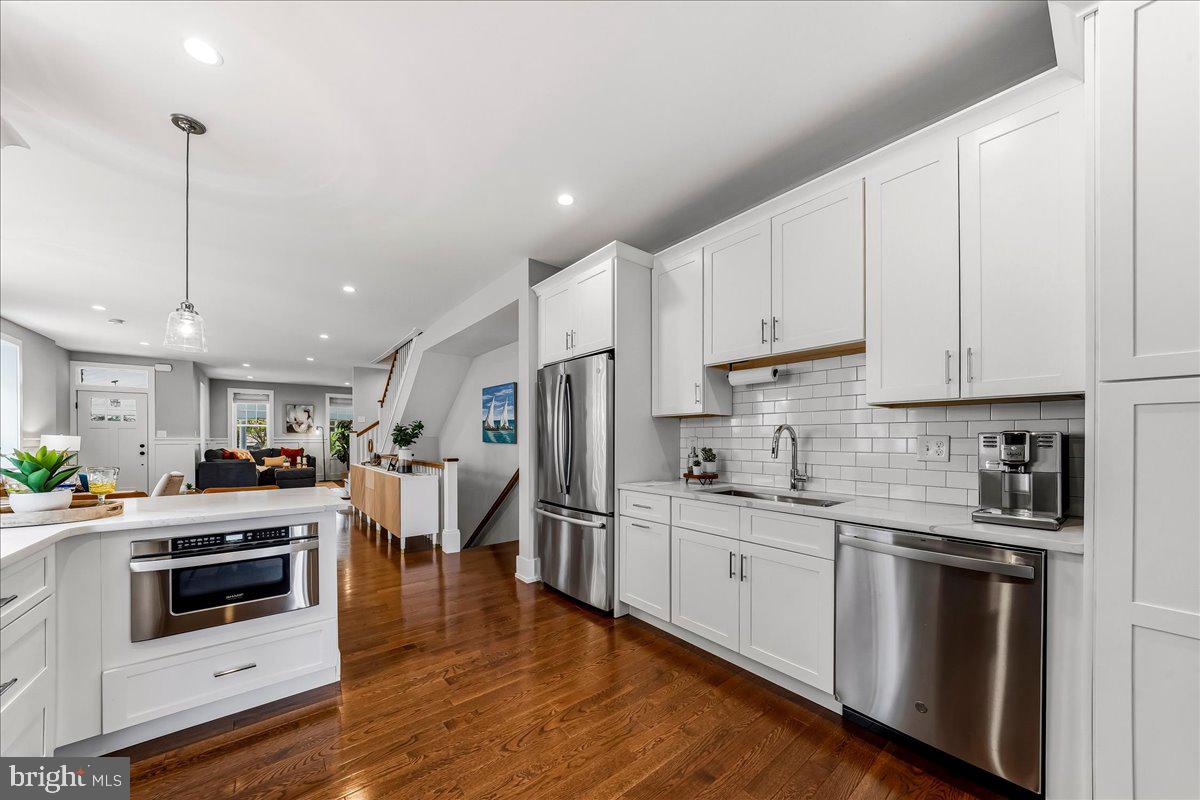 308 Chestnut Avenue Narberth, PA 19072 - Photo 19 of 66 a kitchen with stainless steel appliances granite countertop a stove a sink and white cabinets with wooden floors