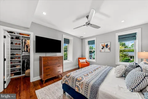 a bedroom with a bed a flat screen tv and a window