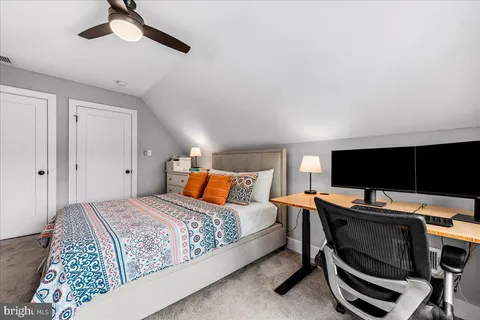 a bedroom with furniture a flat screen tv and a book shelf