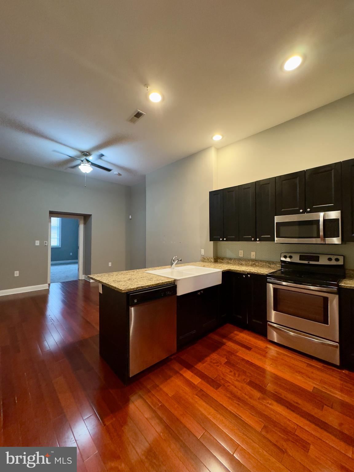 803 Cathedral Street, Unit 4 Baltimore, MD 21201 - Photo 2 of 12 a kitchen with stainless steel appliances granite countertop a stove and a wooden floors