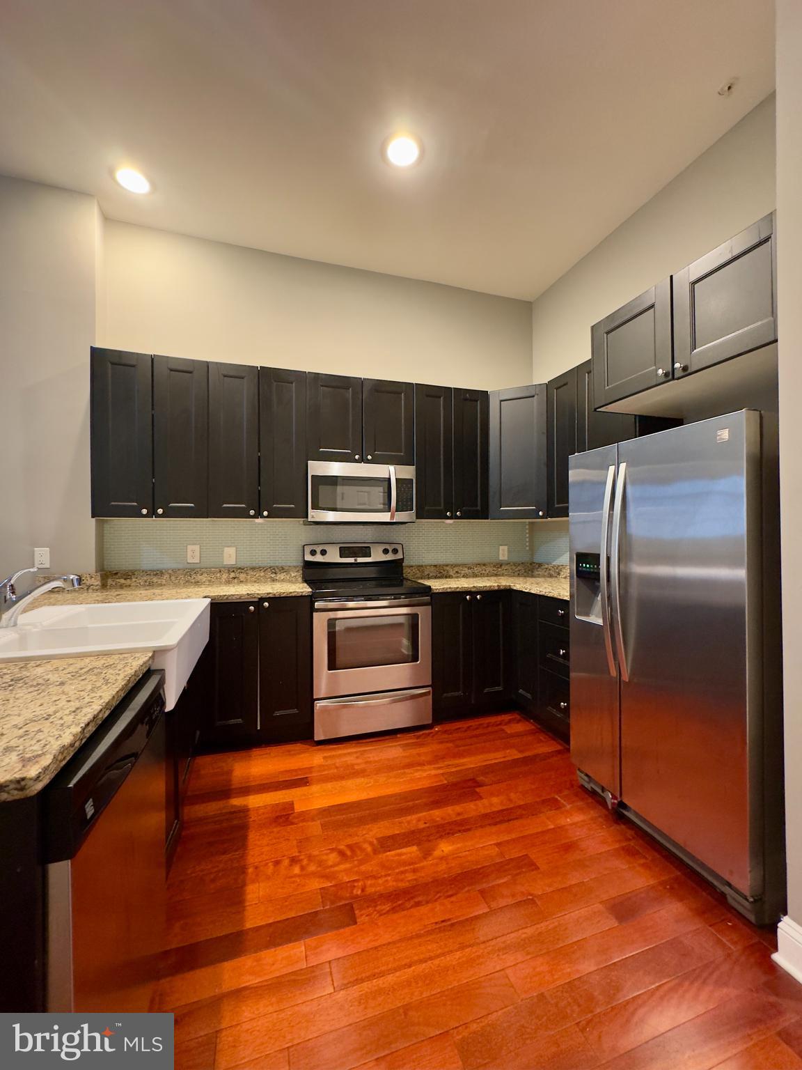 803 Cathedral Street, Unit 4 Baltimore, MD 21201 - Photo 3 of 12 a kitchen with stainless steel appliances granite countertop a refrigerator and a stove