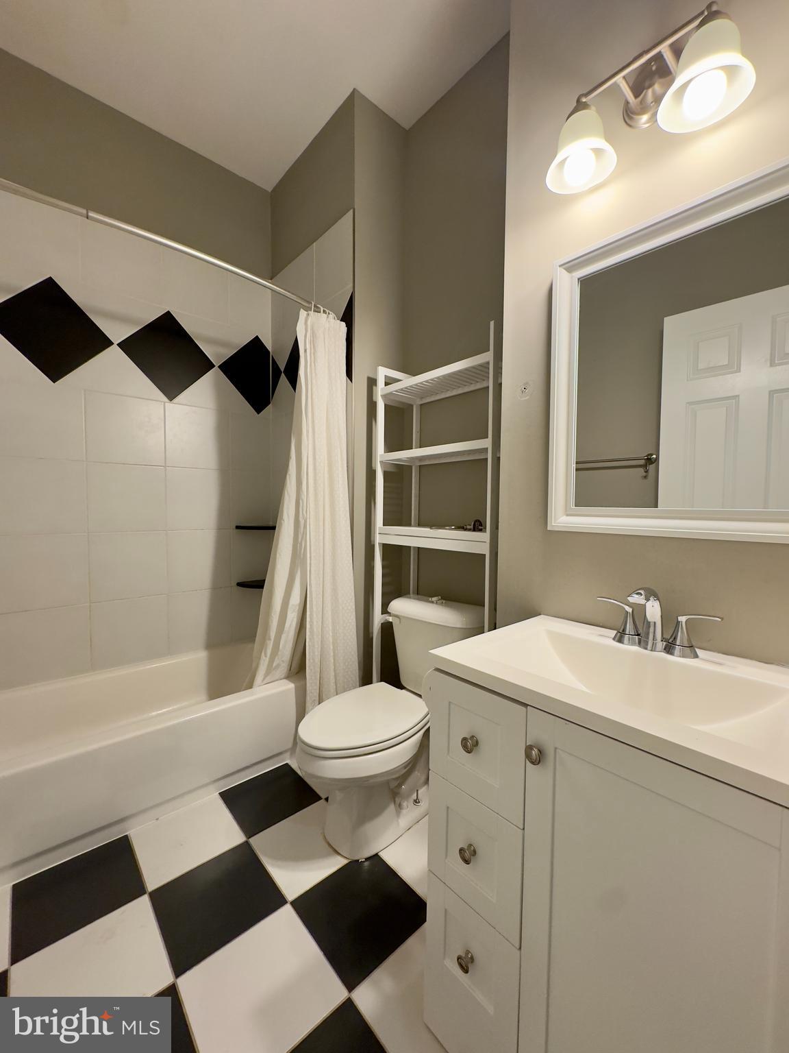 803 Cathedral Street, Unit 4 Baltimore, MD 21201 - Photo 7 of 12 a bathroom with a sink a toilet a mirror and shower