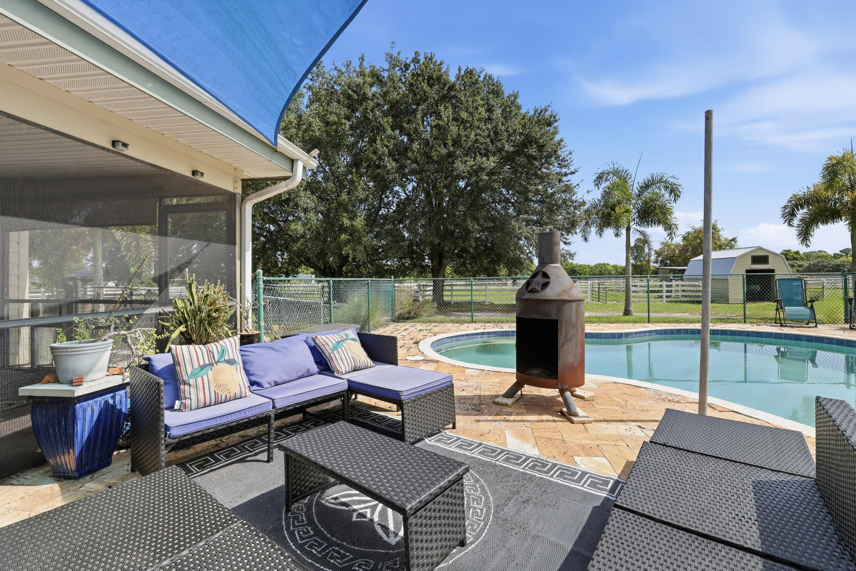 14095 Biddex Road Loxahatchee Groves, FL 33470 - Photo 30 of 69 a view of a patio with couches potted plants and a table