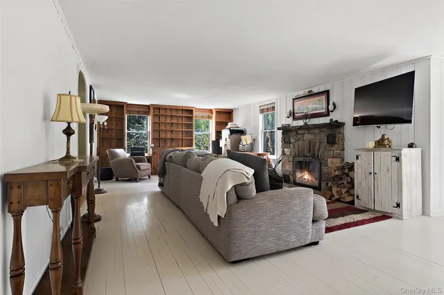 a view of a dining room with furniture one side kitchen view and wooden floor