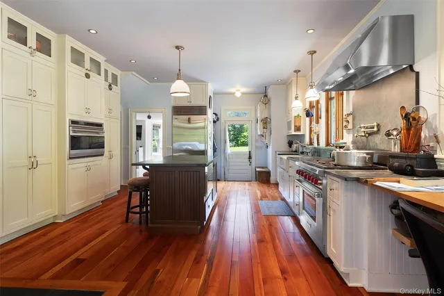 a kitchen with stainless steel appliances a sink window and wooden floor