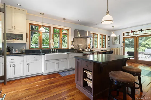 a kitchen with granite countertop a stove a sink dishwasher and white cabinets with wooden floor