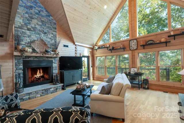 a living room with furniture a fireplace and a floor to ceiling window