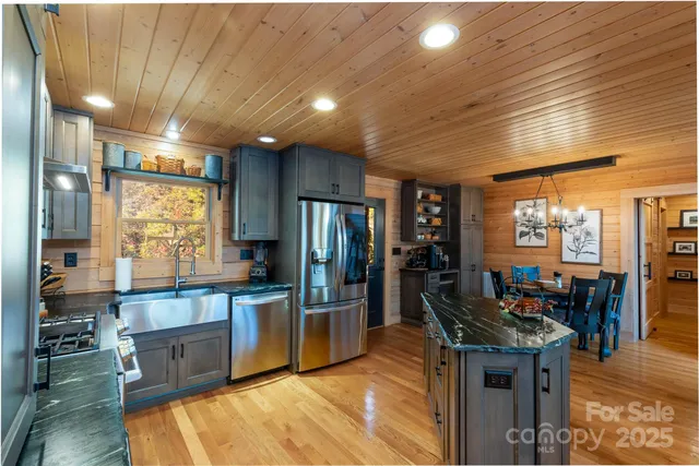 a kitchen with stainless steel appliances granite countertop a stove refrigerator and cabinets
