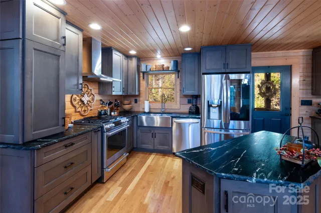 a kitchen with stainless steel appliances granite countertop a stove a sink dishwasher and a refrigerator