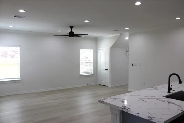 an empty room with wooden floor and window
