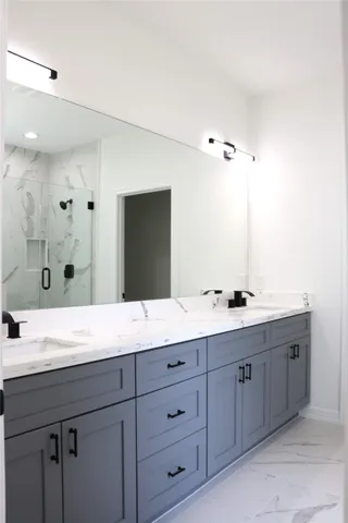 a bathroom with a granite countertop sink double and mirror