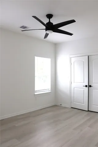 en empty room with window and a ceiling fan
