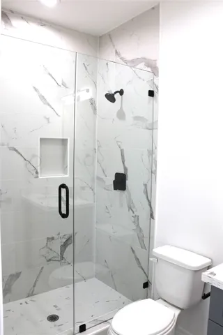 a white toilet sitting next to a bathroom