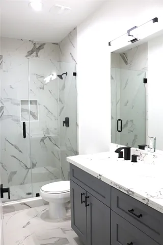 a bathroom with a sink a toilet and shower